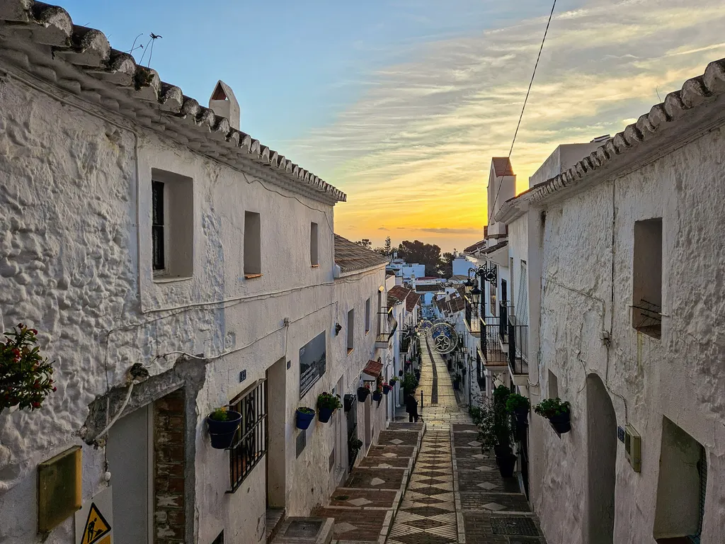 Calle San Sebastián in Mijas Pueblo at sunrise, whitewashed houses with blue flowerpots